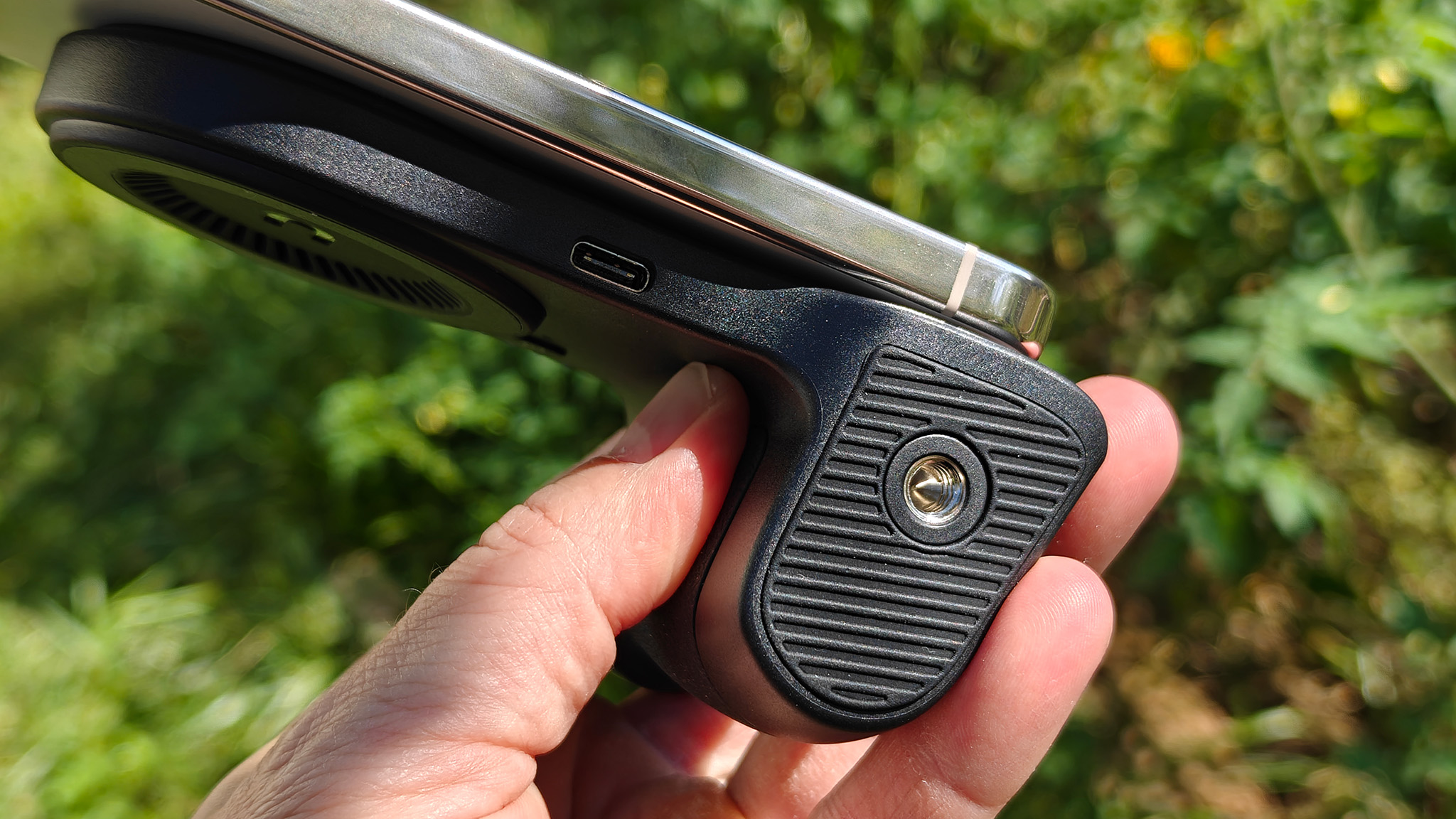 The bottom of a KraftGeek magnetic camera grip showing its USB-C port and standard tripod screw mount