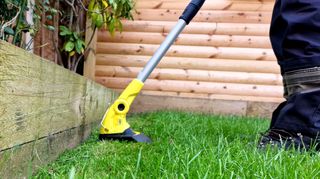 The Karcher LTR 18-30 grass trimmer in garden cutting edge