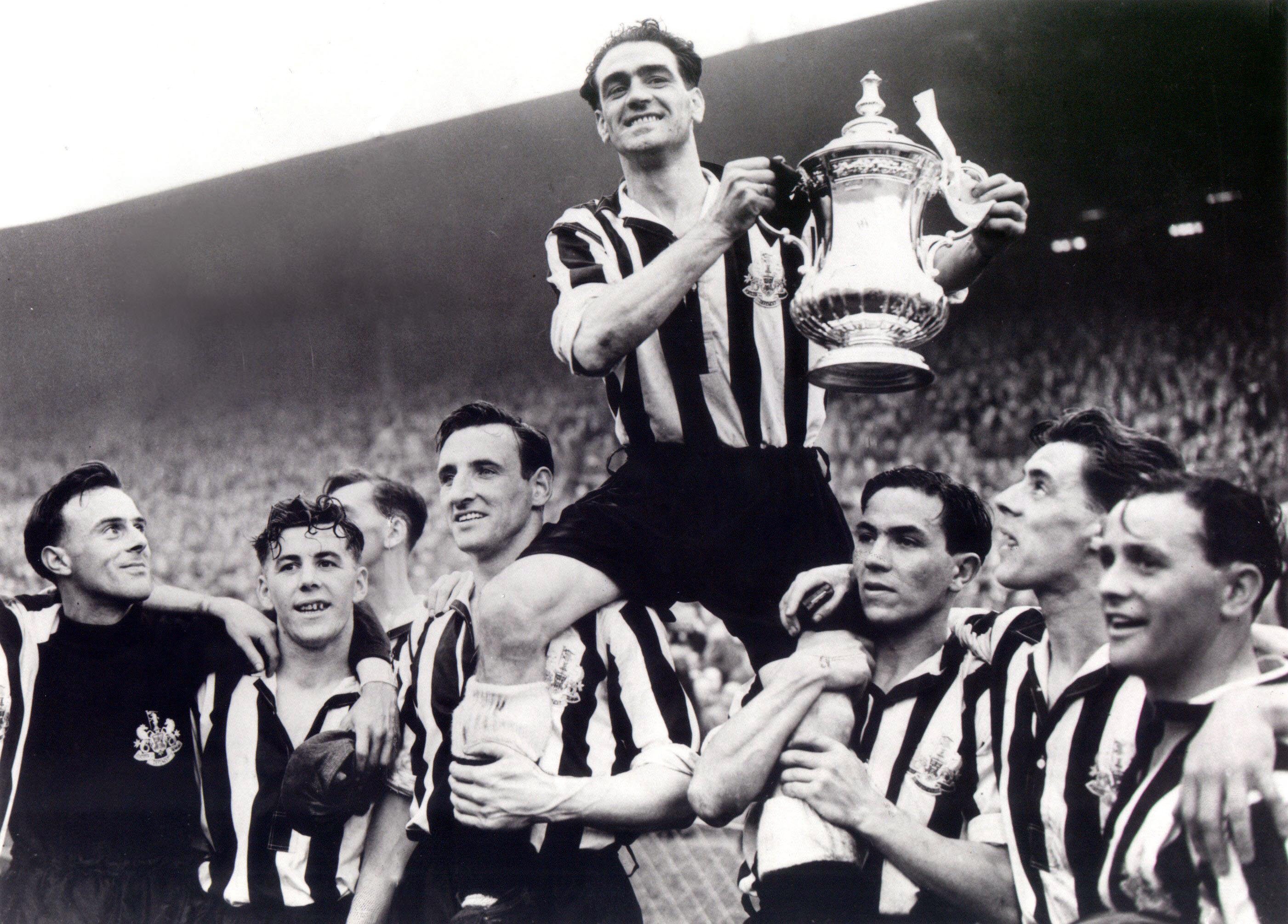 Newcastle captain Joe Harvey (c) is hoisted by his teammates after winning the FA Cup in 1952 - Robledo is holding Harvey's left leg