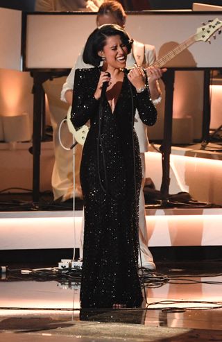 RAYE sings at the 2025 Grammys in a long-sleeve black sequin gown