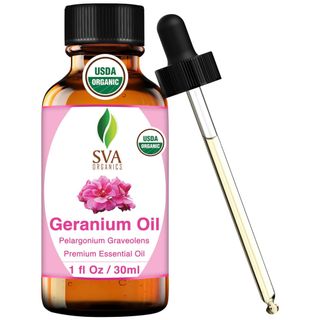 A brown bottle of geranium essential oil with a black lid, pipette, and pink and white label with a pink geranium flower on it