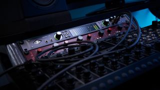 An audio interface and mic preamp in a rack unit in a dimly lit studio