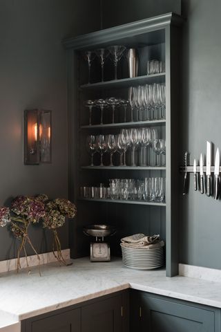 Charcoal grey kitchen with open shelving to store glassware by DeVol