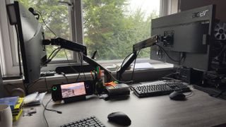 Two monitors attached to monitor arms on a lovely tidy desk.