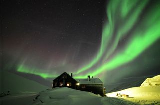 Brilliant northern lights dance over a small hotel high in the Swedish mountains on Feb. 21, 2014 in this image from the video “Lights Over Lapland” by Chad Blakley.