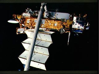 The Upper Atmosphere Research Satellite is in the grasp of the remote manipulator system end effector above the payload bay of the Earth-orbiting Discovery during STS-48 pre-deployment checkout procedures.