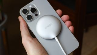 Anker MagGo Wireless Charging Pad attached to an iPhone 15 Pro Max and held in a hand