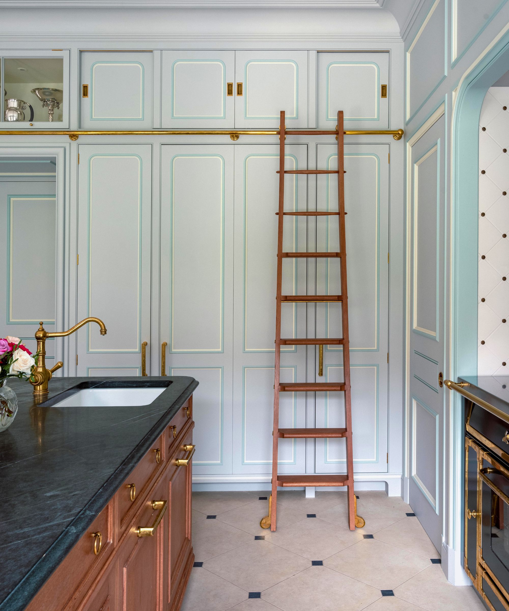 A blue kitchen with a wooden kitchen ladder