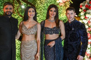 Indian actress and producer Priyanka Chopra Jonas (2R), along with her husband, American singer and actor Nick Jonas (R), poses for a photograph at her brother Siddharth Chopra's (L) and his fiancée actress Neelam Upadhyaya's Sangeet ceremony