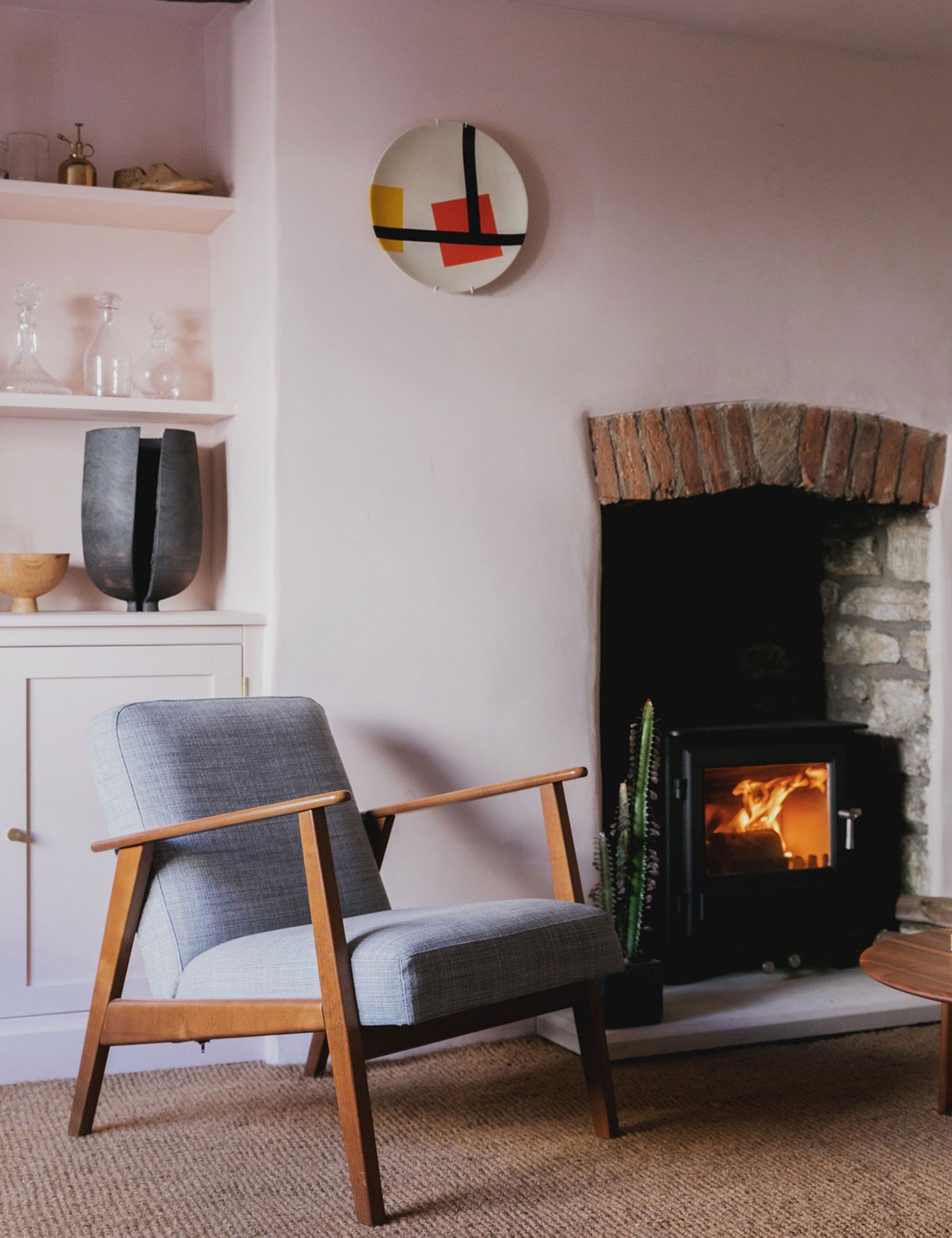 Pink living room with scandi grey chair and fireplace