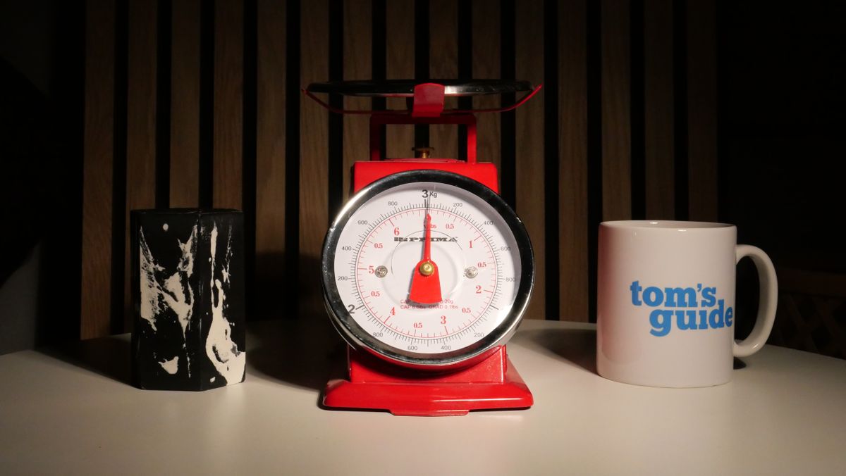 A photo of a set of red scales next to a Tom's Guide Mug.