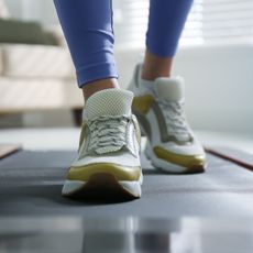 Best walking pads: A woman on a walking pad at home getting her daily steps in