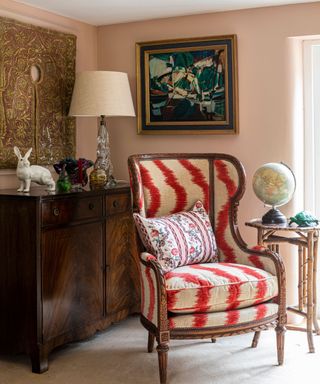 A french country living room with an upholstered armchair and rattan side table