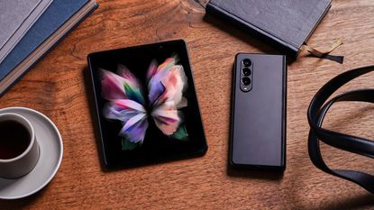 Two Samsung Galaxy Z Fold 3 handsets on a table, one open and unfolded and one closed shut