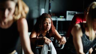 How to exercise without hurting your knees: Image of woman working out on a bike at the gym