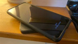 A Samsung S21+ on a wireless charger next to a bedside table
