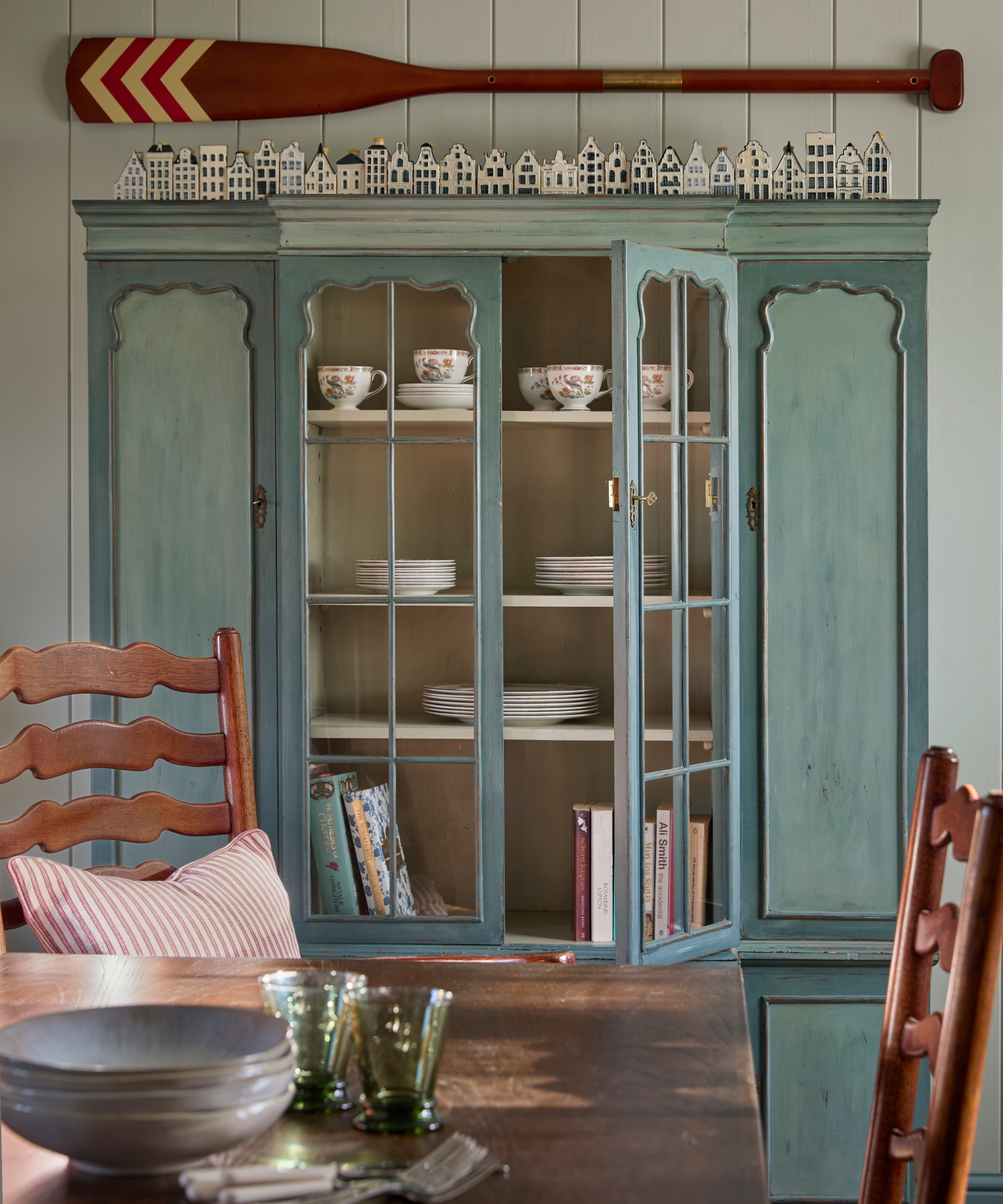 A close up of an antique freestanding kitchen cabinet painted mid blue with a textural finish
