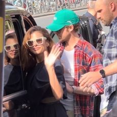 Eva Mendes wearing a navy blue knee-length dress with cream sunglasses and white pumps to the Olympics in Paris with husband Ryan Gosling.