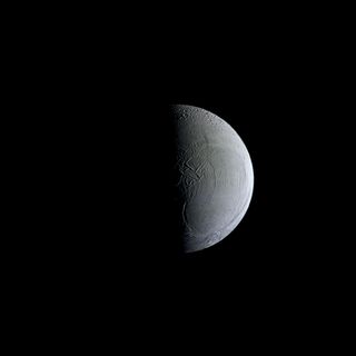 NASA's Cassini spacecraft captures a still and partially sunlit Enceladus, the icy moon of Saturn, in this image released on Dec. 23, 2013.
