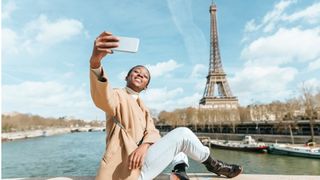Woman taking selfie with the Eiffel Tower