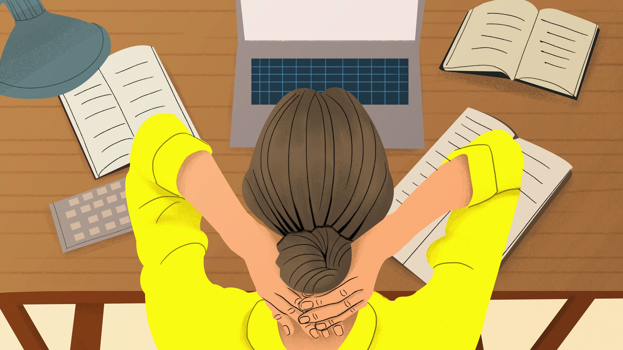 Woman at desk with laptop and book