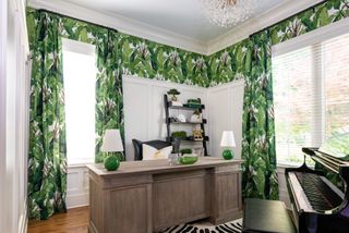 freestanding desk in home office with foliage pattern wallpaper