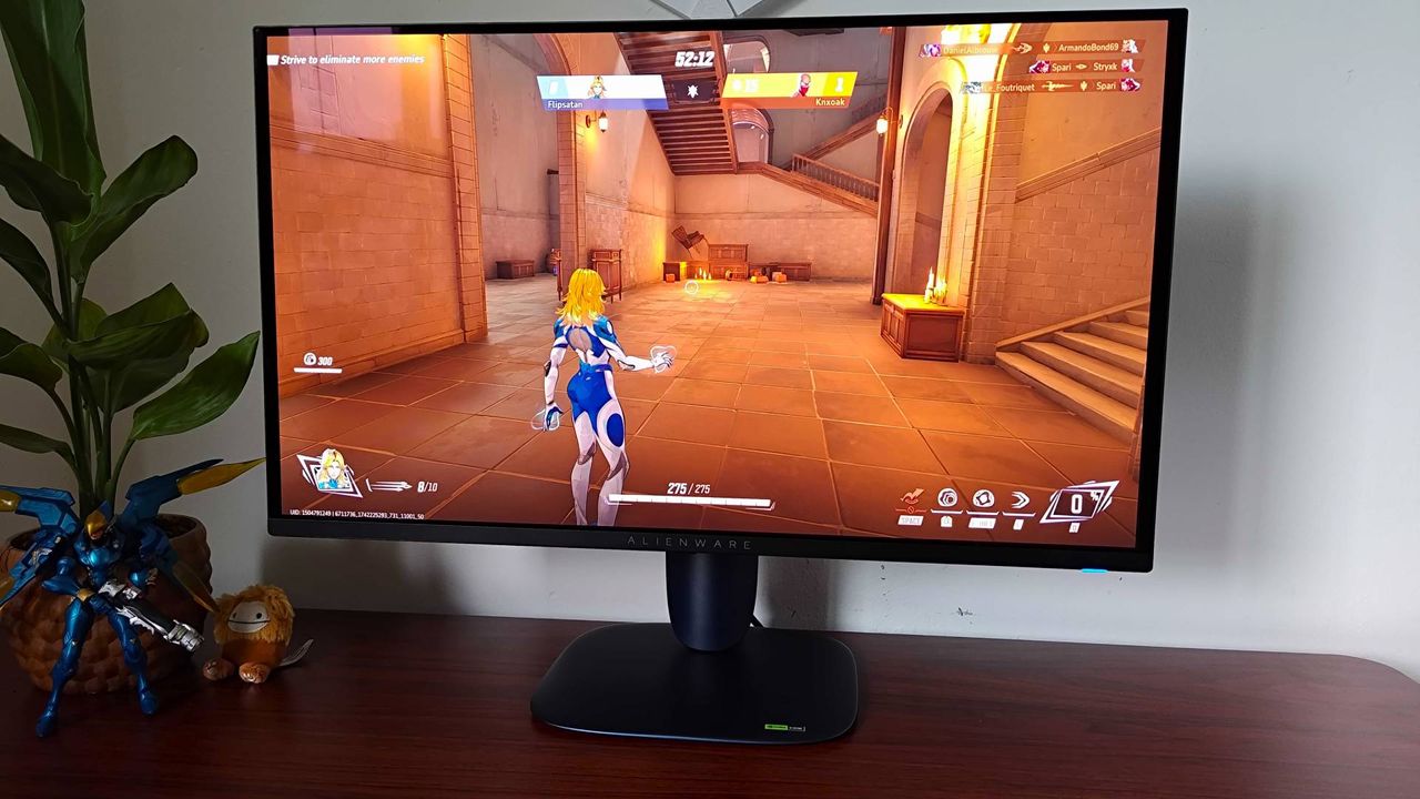 Alienware AW2725Q gaming monitor with Marvel Rivals gameplay on screen featuring Invisible Woman in stone room.