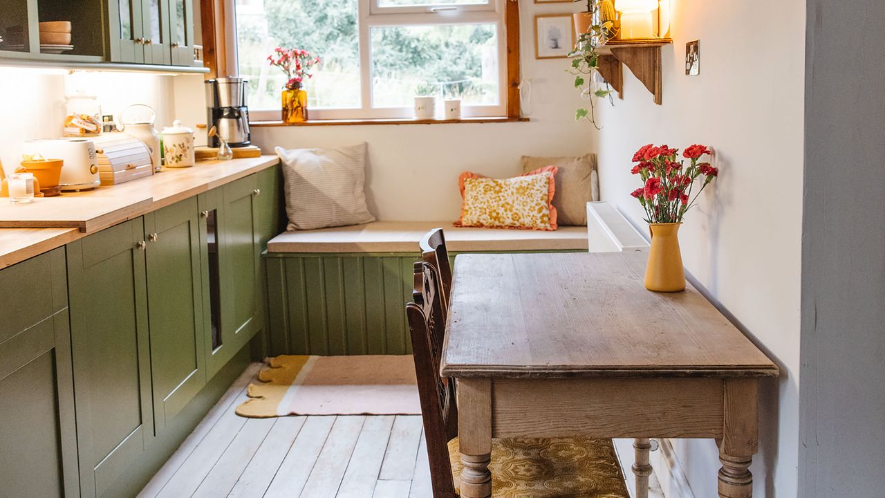 Green kitchen with oak worktops, window seat and farmhouse table.