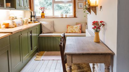 Green country kitchen makeover with shaker cupboards and farmhouse table.