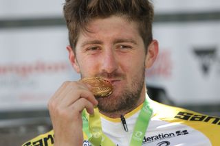 Luke Durbridge (Mitchelton-Scott) takes a bite of his medal