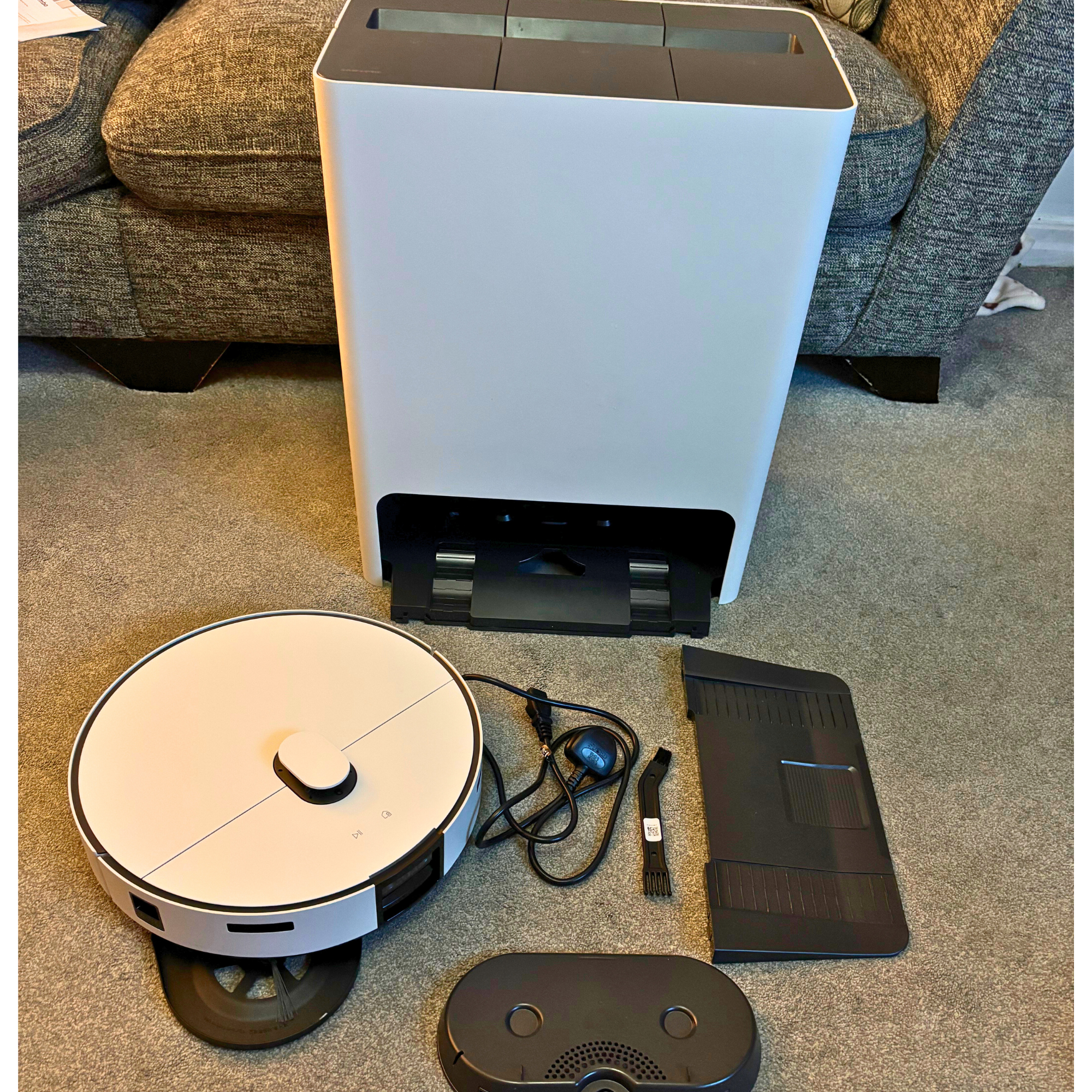 Samsung Bespoke Jet Bot Combo robot vacuum cleaner and cleaning station, plus accessories aligned on carpet