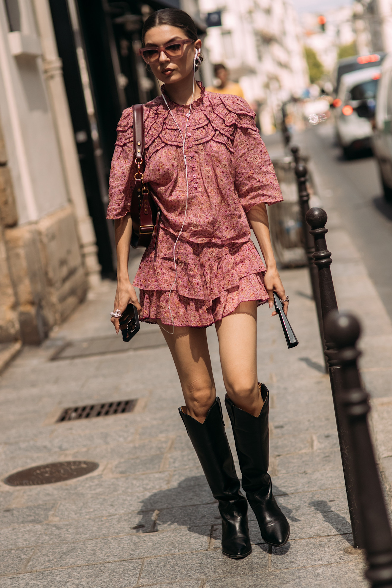 fashion week attendee wearing sunglasses, mini floral dress, and knee-high boots