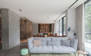 Lounge area in natural tones, with several sofas and a bookcase