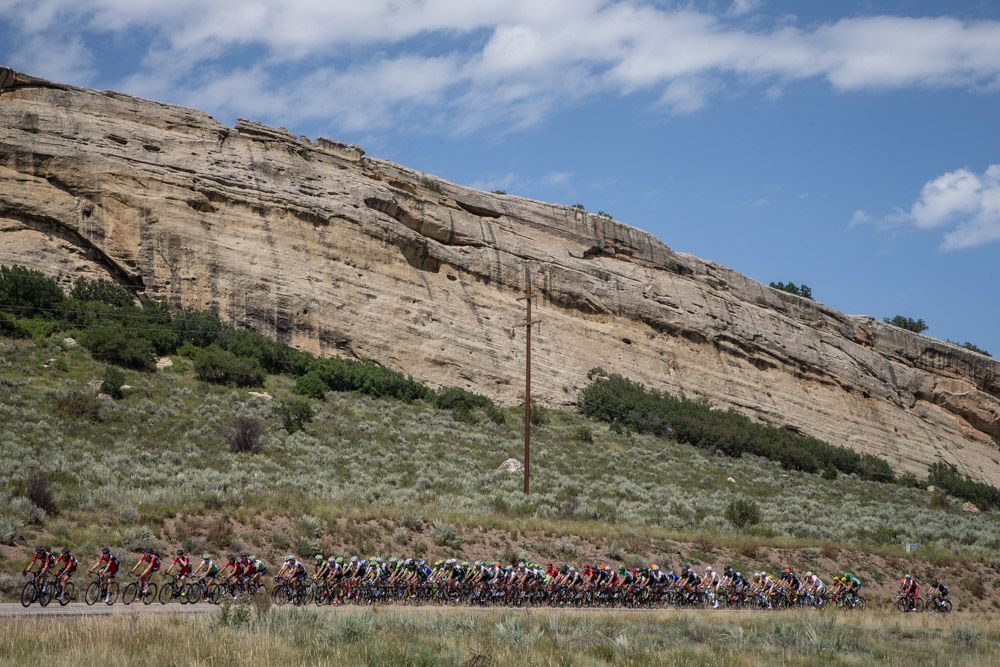 The peloton passes rock landscapes along todays route