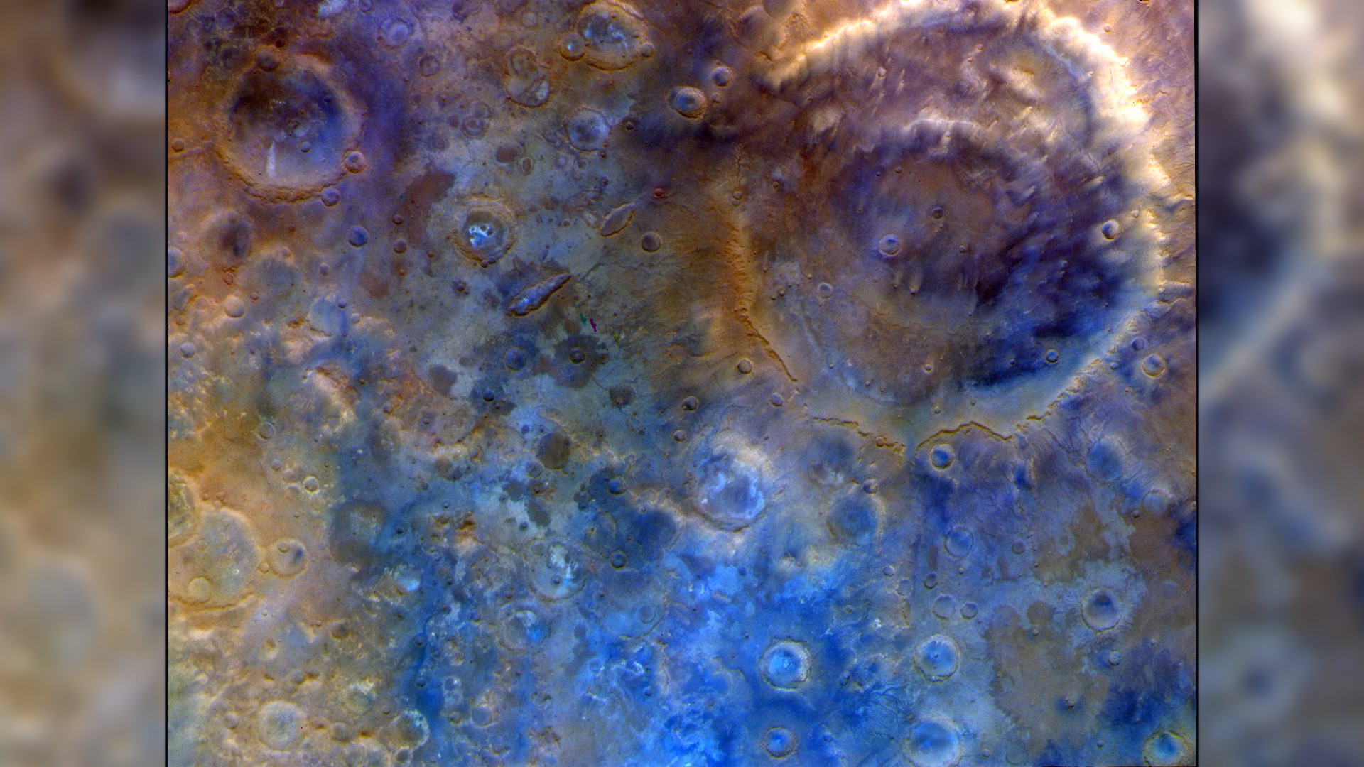 a colorful image of a deep crater surrounded by lots of smaller craters