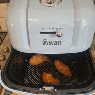 Close up of chicken cooking in a Swan Retro air fryer