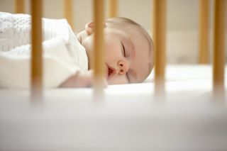close up of baby sleeping in cot