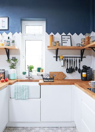 blue and white kitchen with wooden worktops filled with kitchen essentials but styled with the principles of the curated clutter trend