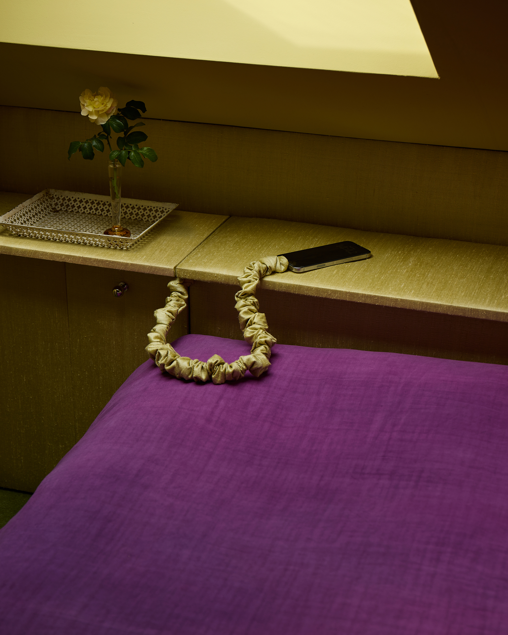 a green and purple bedroom side and bed linen