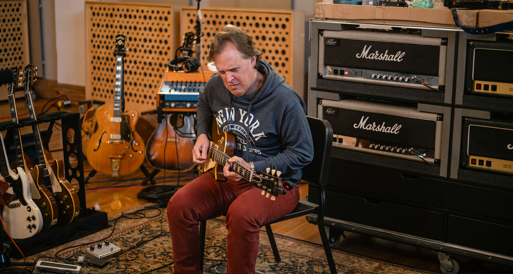 Joe Bonamassa lays down a track in the studio with a vintage Les Paul, Marshall amps in the background.