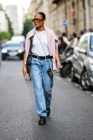 woman wearing white tank, jeans, and loafers