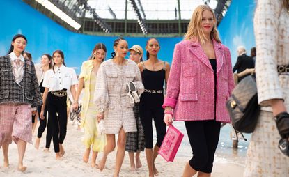 Models wear tweed blazers in pink, black and yellow, white denim shirt with black leggings, black top with black leggings and Chanel belt