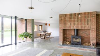 polished concrete floor in living room with stove and view of dining table
