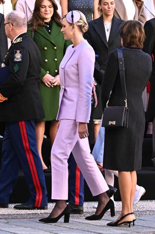 Princess Charlene wears a lilac pant suit and her engagement ring from Prince Albert for Monaco Day