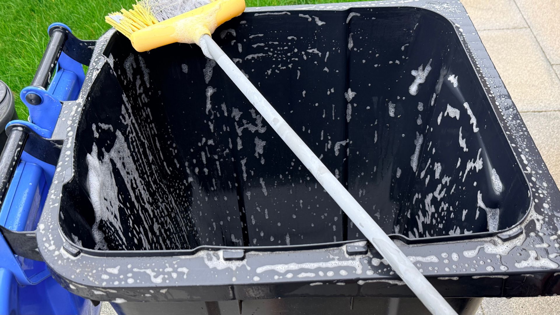 picture of wheelie bin with soap inside and garden broom