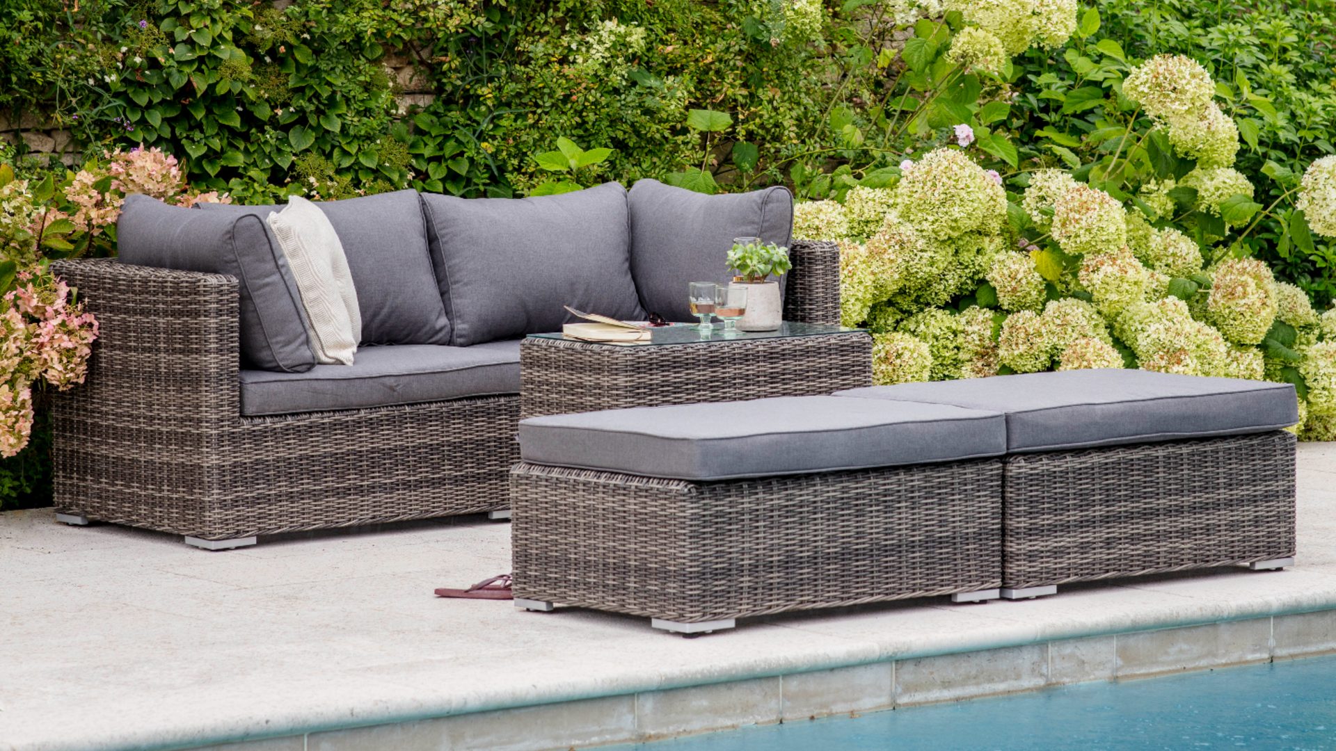 A grey and rattan-effect garden sofa - Garden Trading