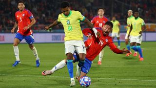 Brazil's Rodrygo shields the ball from a challenge from Chile's Felipe Loyola during an October 2024 World Cup qualifier.