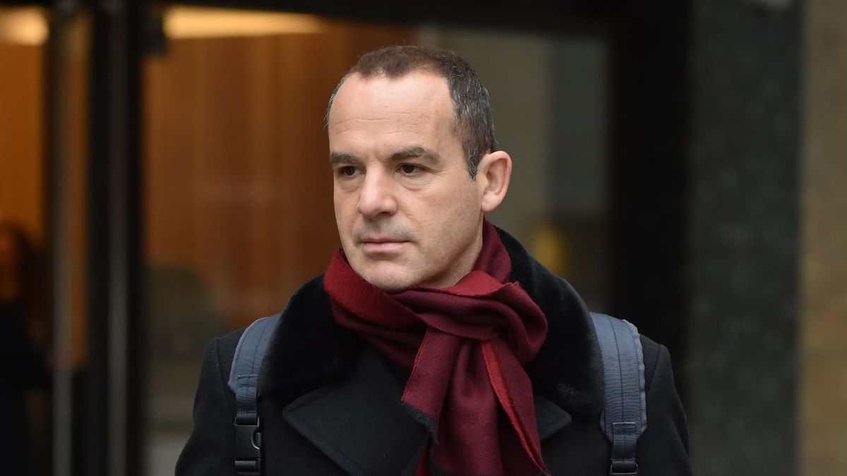 Martin Lewis in a scarf and coat with a backpack