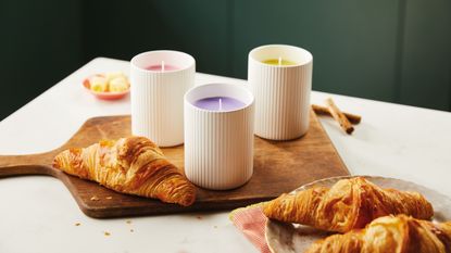 Scented candles on wooden chopping board and pastries