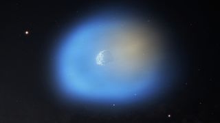 An artist's impression of the interstellar comet 3I/ATLAS, with methanol (blue) flowing from both its nucleus and icy grains in the coma, while hydrogen cyanide (orange) is released mainly from the nucleus.